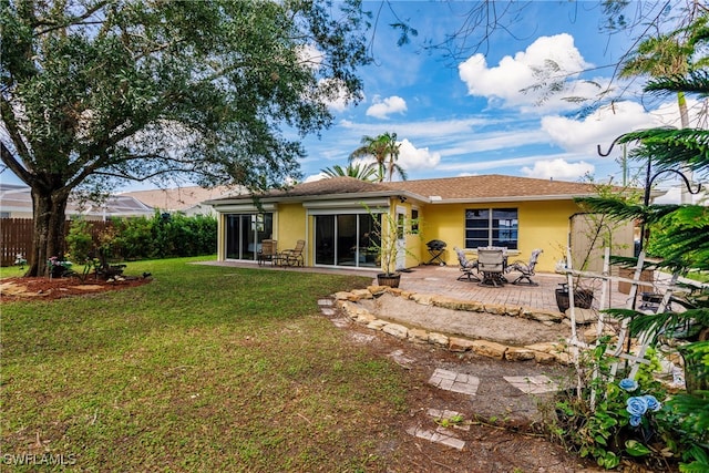 back of property featuring a patio, a sunroom, and a lawn