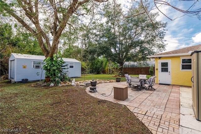 view of yard featuring a patio, a shed, and a fire pit