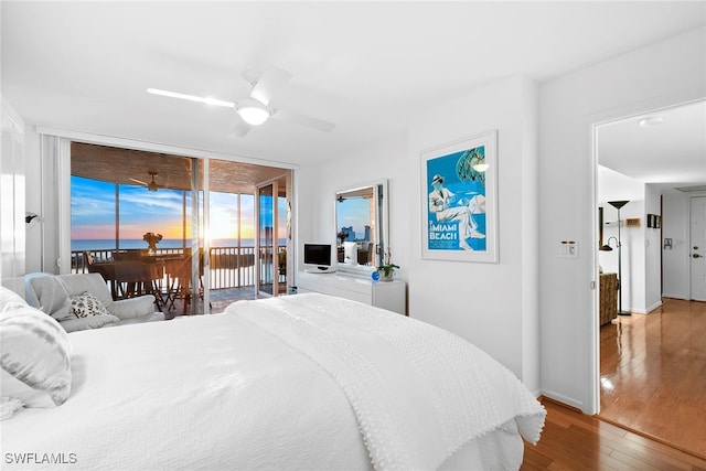 bedroom with ceiling fan, access to outside, wood-type flooring, and floor to ceiling windows