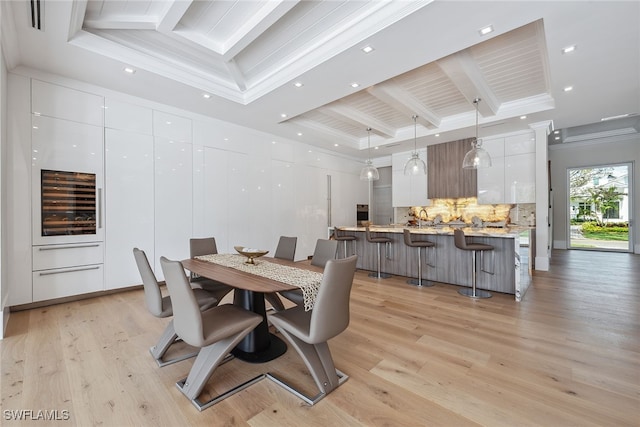 dining area with crown molding, beamed ceiling, light wood-type flooring, and a raised ceiling