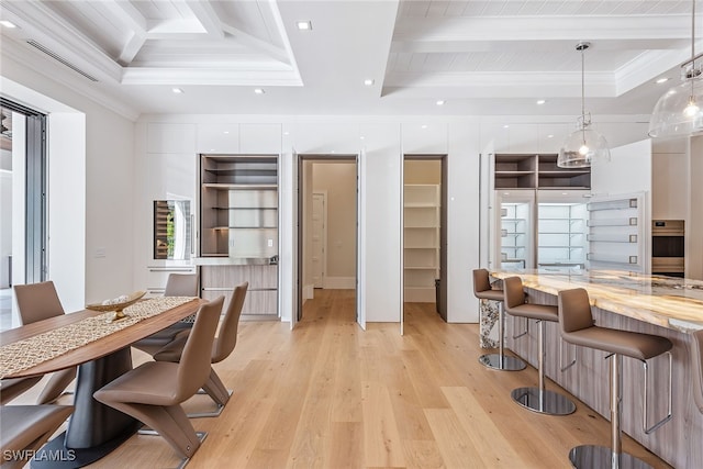 dining room featuring ornamental molding, a tray ceiling, light wood-type flooring, and beamed ceiling