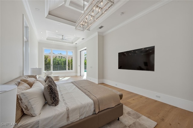 bedroom featuring crown molding, a tray ceiling, and hardwood / wood-style flooring