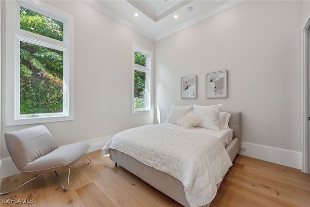 bedroom featuring crown molding and light hardwood / wood-style flooring