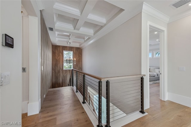 hallway featuring a notable chandelier, light hardwood / wood-style floors, coffered ceiling, and beam ceiling