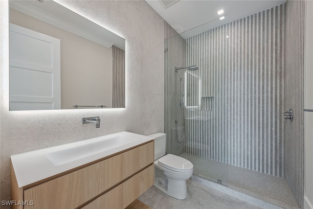 bathroom with vanity, toilet, and tiled shower