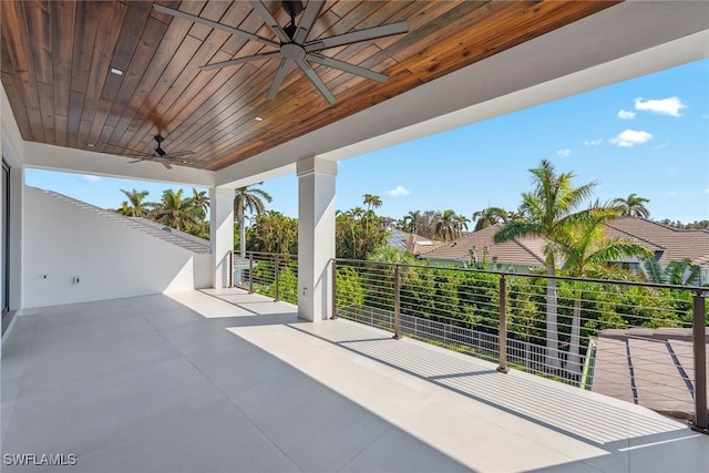 view of patio with ceiling fan and a balcony