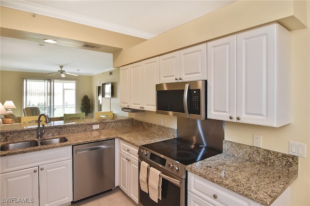 kitchen with stone counters, sink, ceiling fan, stainless steel appliances, and white cabinets