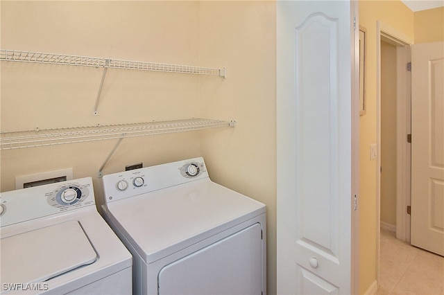 laundry area featuring washing machine and clothes dryer and light tile patterned floors