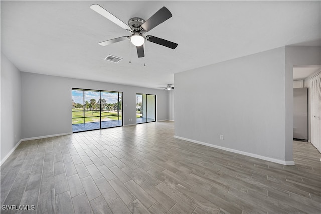 spare room with ceiling fan and light wood-type flooring