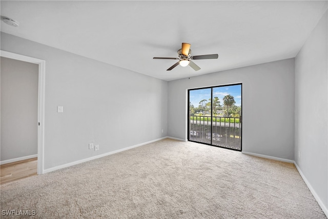 carpeted spare room featuring ceiling fan