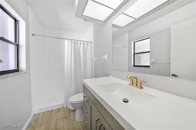 bathroom featuring toilet, hardwood / wood-style flooring, vanity, and a shower with shower curtain