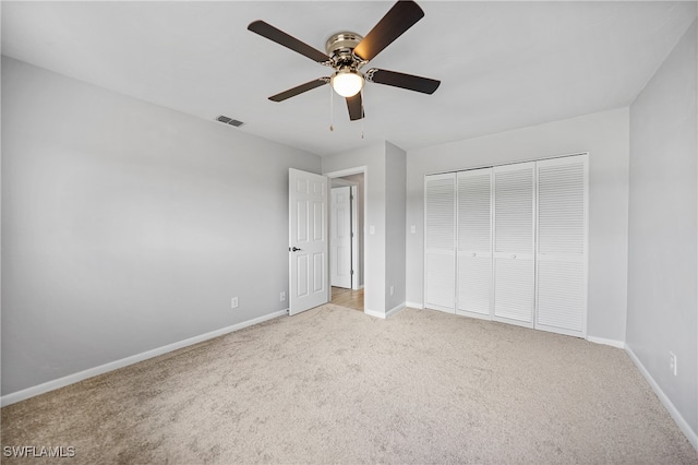 unfurnished bedroom with light colored carpet, a closet, and ceiling fan