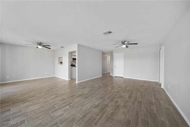 unfurnished living room featuring dark wood-type flooring and ceiling fan