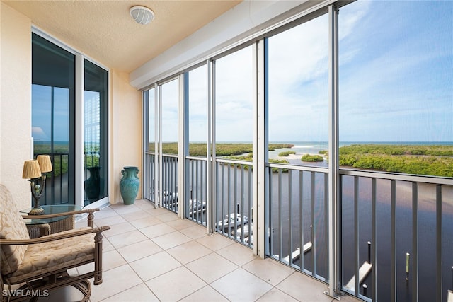 sunroom / solarium featuring a water view