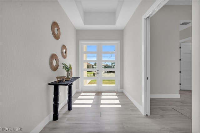 foyer featuring french doors, visible vents, baseboards, and wood finished floors