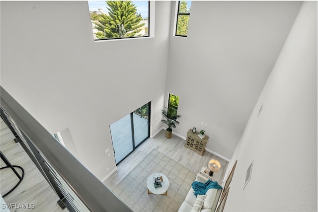 living area featuring a high ceiling, wood finished floors, and baseboards