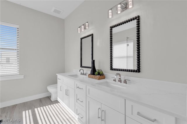 bathroom with baseboards, visible vents, a sink, and toilet