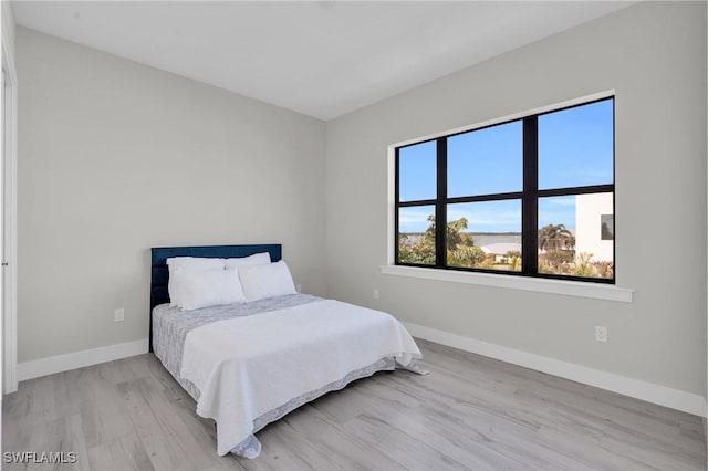 bedroom with light wood-style floors and baseboards