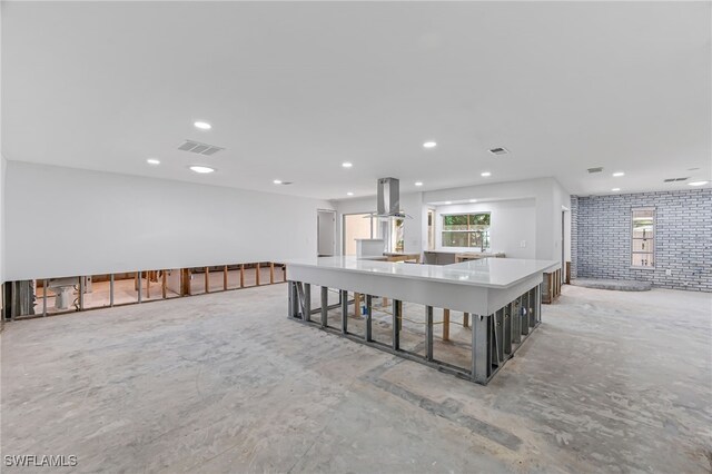 kitchen with island exhaust hood, a kitchen bar, and a kitchen island