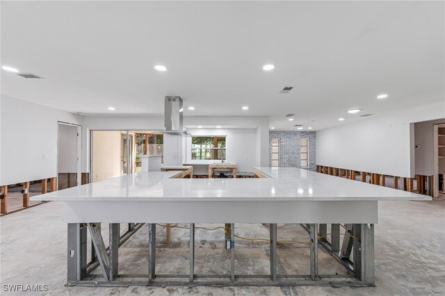 kitchen featuring island range hood, concrete floors, and a large island