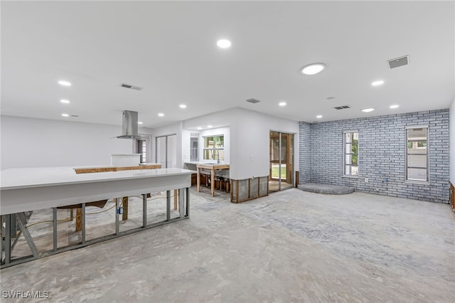 2472 Harbor Rd, Naples, FL 34104 - empty room with brick wall, unfinished concrete flooring, and recessed lighting