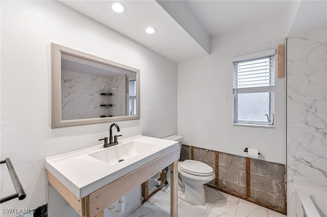 bathroom with toilet, sink, and a tub