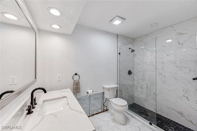 bathroom with tiled shower, vanity, and toilet