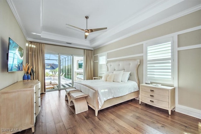 bedroom featuring wood-type flooring, access to outside, a raised ceiling, ceiling fan, and crown molding