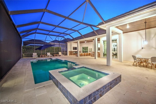 pool at dusk featuring an in ground hot tub, a lanai, and a patio area