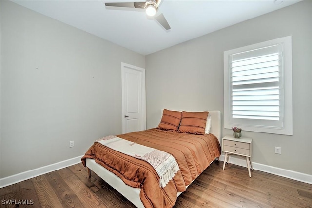 bedroom featuring ceiling fan, baseboards, and wood finished floors