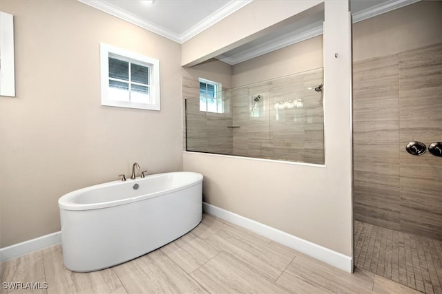 full bath featuring a freestanding tub, baseboards, walk in shower, and ornamental molding