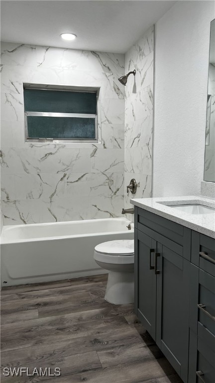 full bathroom with vanity, tiled shower / bath combo, wood-type flooring, and toilet