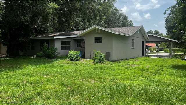 back of property featuring a yard and a carport