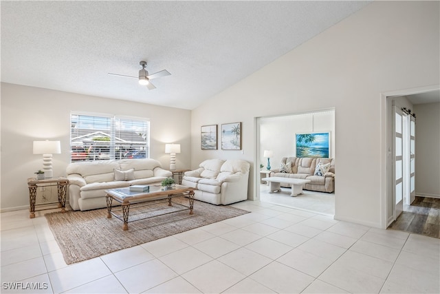 tiled living room with a textured ceiling, high vaulted ceiling, and ceiling fan