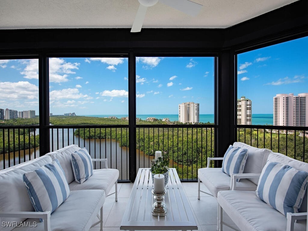 sunroom featuring a water view and ceiling fan