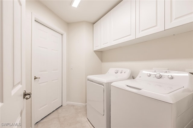 clothes washing area with light tile patterned floors, separate washer and dryer, and cabinets