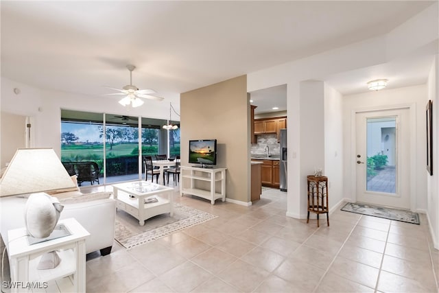 living room with ceiling fan, sink, and light tile patterned flooring