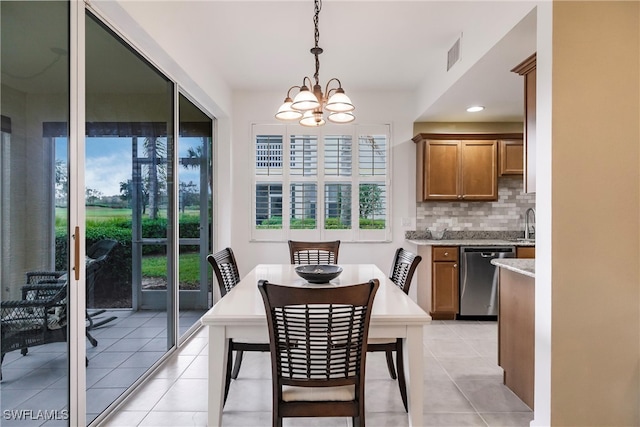 tiled dining area featuring sink and an inviting chandelier