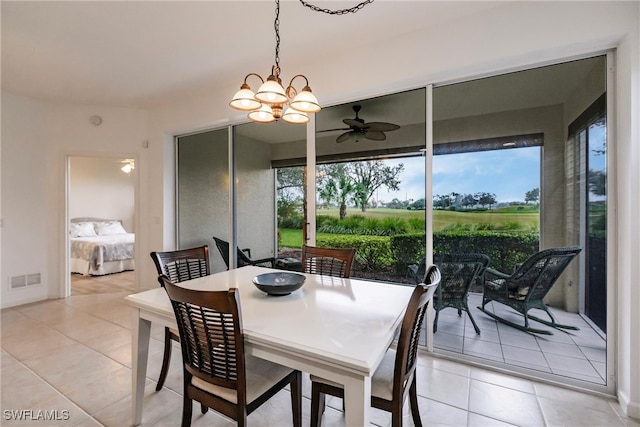 dining area with light tile patterned floors and ceiling fan with notable chandelier