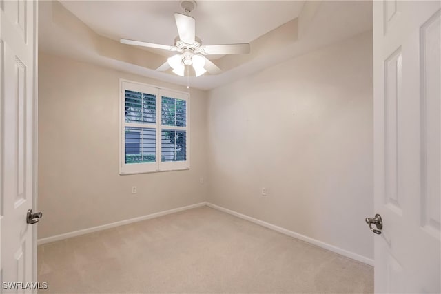 spare room with ceiling fan and light colored carpet