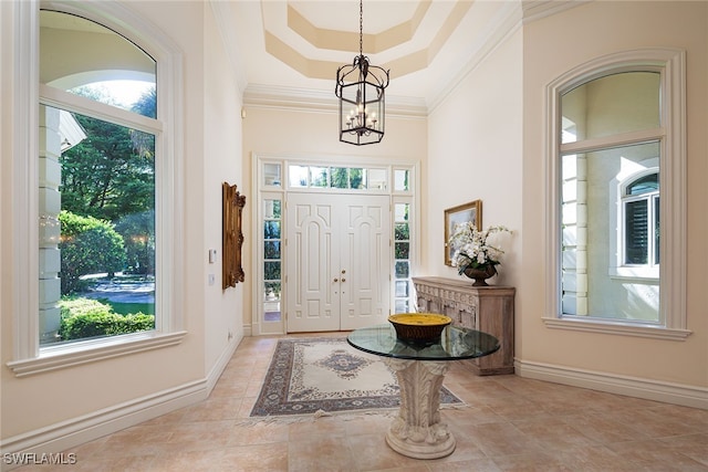 foyer entrance featuring crown molding and an inviting chandelier