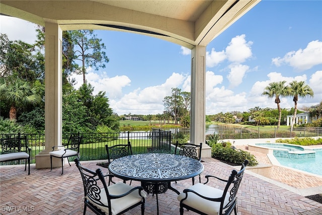 view of patio / terrace featuring a water view and a fenced in pool