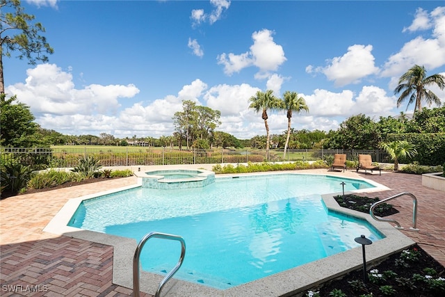 view of swimming pool featuring a patio area and an in ground hot tub