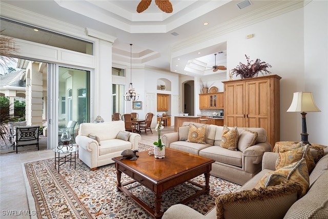 tiled living room with crown molding, a raised ceiling, and ceiling fan with notable chandelier