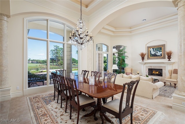 dining room with a high ceiling, ornamental molding, decorative columns, a notable chandelier, and light tile patterned floors