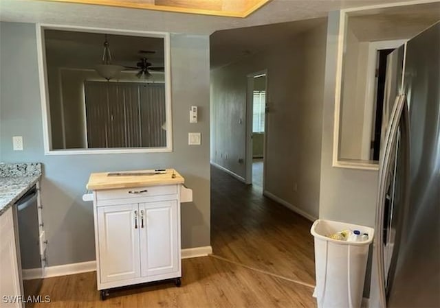 bathroom with ceiling fan and wood-type flooring