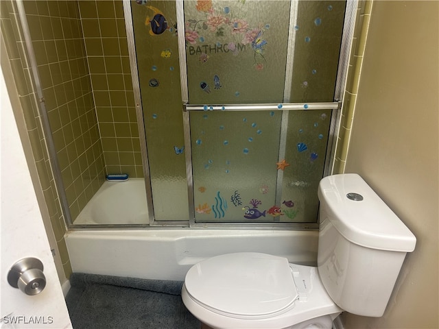 bathroom featuring toilet and bath / shower combo with glass door