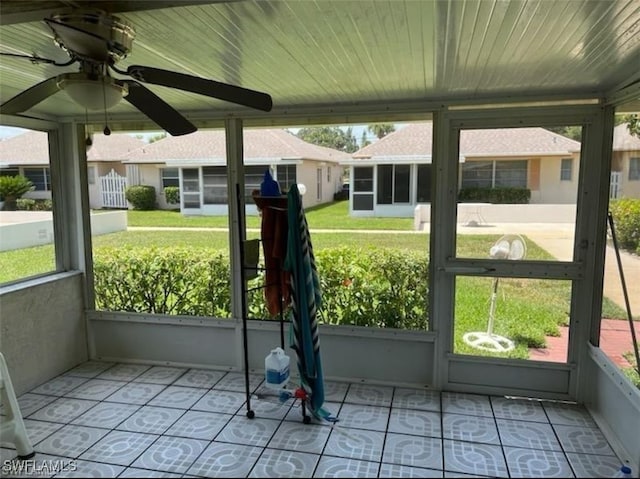 unfurnished sunroom featuring ceiling fan