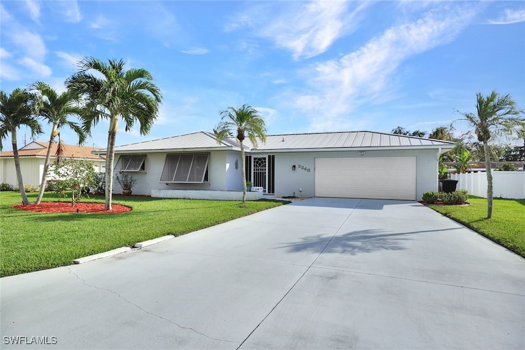 ranch-style home with a garage and a front lawn