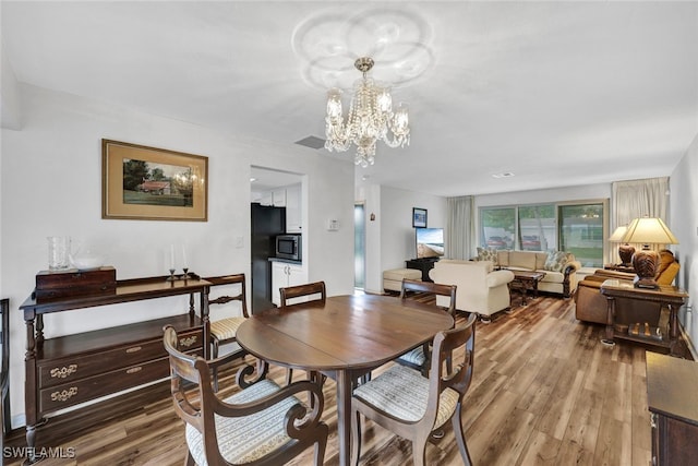 dining area featuring an inviting chandelier and wood-type flooring